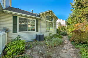 View of property exterior with a shingled roof and a central air condition unit