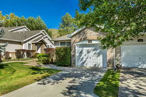 Ranch-style house with concrete driveway, a garage, a front lawn, and brick siding