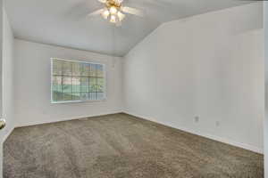 Spare room featuring carpet, lofted ceiling, and ceiling fan