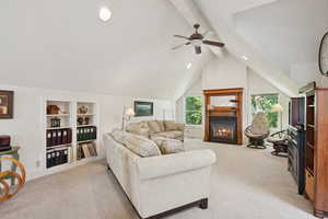 Carpeted living room with recessed lighting, a glass covered fireplace, and a ceiling fan