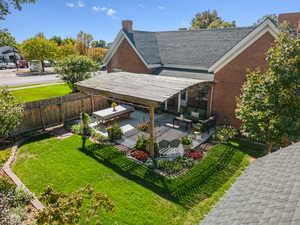 Back of property featuring a patio, an outdoor living space, brick siding, a chimney, and a pergola