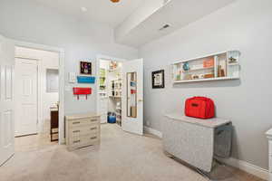 Bedroom with light colored carpet and electric panel