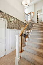 Stairway with tile patterned floors and a high ceiling