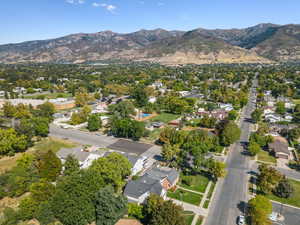 Aerial view of property and surrounding area featuring nearby suburban area and a mountainous background