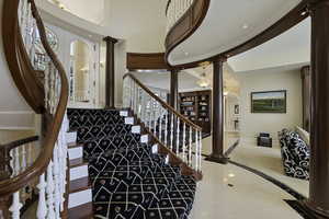Stairs with ornate columns, recessed lighting, tile patterned flooring, and arched walkways