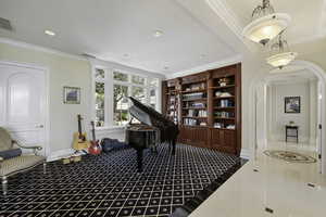 Sitting room featuring crown molding, arched walkways, recessed lighting, and dark tile patterned flooring