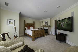 Carpeted bedroom featuring ornamental molding, a fireplace, and recessed lighting
