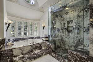 Bathroom with a garden tub, marble finish floors, a marble finish shower, ornamental molding, and lofted ceiling
