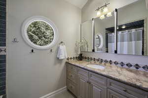 Full bath with vanity, tasteful backsplash, and curtained shower