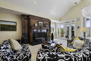Living area with high vaulted ceiling, carpet floors, a fireplace, french doors, and recessed lighting