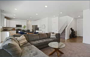 Living room featuring stairway, recessed lighting, and wood finished floors