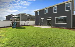 Back of house featuring a patio area, a playground, and stucco siding