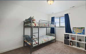 Bedroom with light colored carpet and baseboards