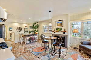 Dining room with recessed lighting, a fireplace, wooden walls, and brick patterned floors