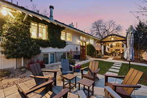 Back of house at dusk with a patio area, a gazebo, and outdoor dining area