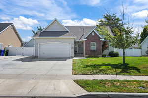 View of front of house featuring a gate, driveway, a shingled roof, and a garage
