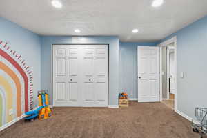 Recreation room featuring a textured ceiling, carpet, and recessed lighting