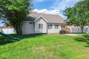 Back of house featuring a shingled roof, a playground, and a patio
