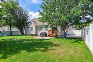 Rear view of house with a patio, a fenced backyard, and roof with shingles