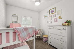 Bedroom featuring dark carpet and ceiling fan