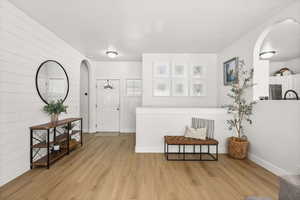 Sitting room with arched walkways and light wood finished floors