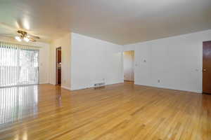 Spare room with light wood finished floors and a ceiling fan
