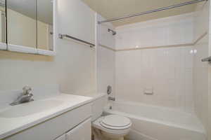 Bathroom featuring shower / washtub combination, vanity, and a textured ceiling