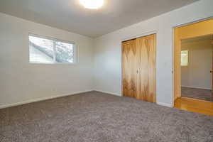 Unfurnished bedroom with carpet flooring and a closet
