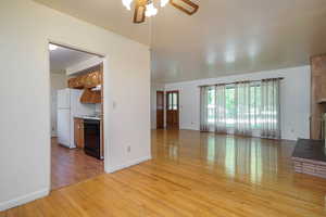 Unfurnished living room featuring light wood-style floors and ceiling fan
