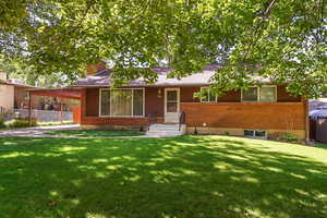 Ranch-style home featuring brick siding and a chimney