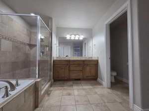Master bathroom with tile floors, double vanity, a jetted tub, and a shower stall