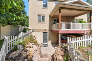 Back of house with a fenced backyard, stucco siding, a patio area, and a deck