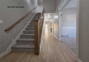 Stairs featuring wood finished floors and baseboards