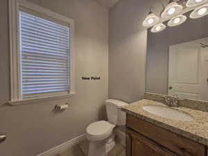 Half bath with vanity, tile floors, and a chandelier