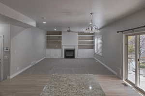 Updated living room featuring a glass covered fireplace, new wall paint and new carpeting