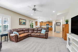 Living room featuring light colored carpet, a ceiling fan, recessed lighting, and a chandelier