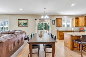 Dining room with hardwood flooring, recessed lighting, and a chandelier