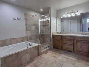 View of master bathroom with jetted tub and glass shower stall