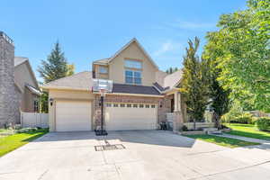 View of front of home featuring stucco siding, driveway, and roof with shingles