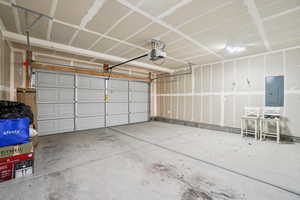 Garage with electric panel and a garage door opener