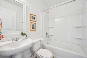 Bathroom featuring tub / shower combination and toilet