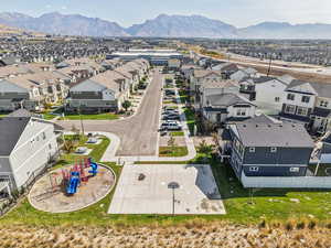 Aerial perspective of the home, the community, and community playground in view with a mountain backdrop