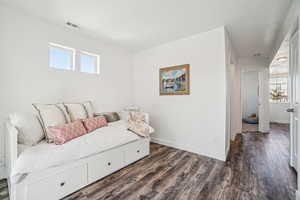 Bedroom featuring dark wood-type flooring and baseboards