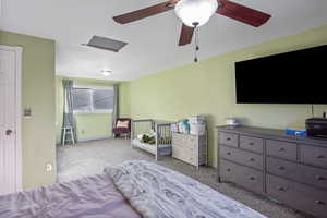 Carpeted bedroom featuring a ceiling fan and baseboards