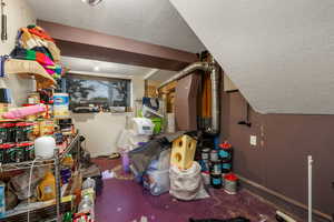 Additional living space with a textured ceiling and concrete flooring