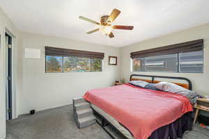 Carpeted bedroom featuring baseboards and ceiling fan