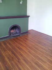 Unfurnished living room with dark wood finished floors and a fireplace
