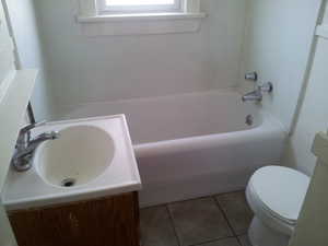 Full bath with a garden tub, vanity, and light tile patterned flooring