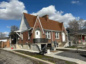 View of property exterior featuring brick siding, a chimney, and roof with shingles