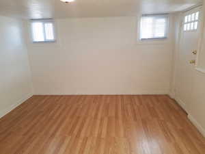 Basement with light wood-style flooring